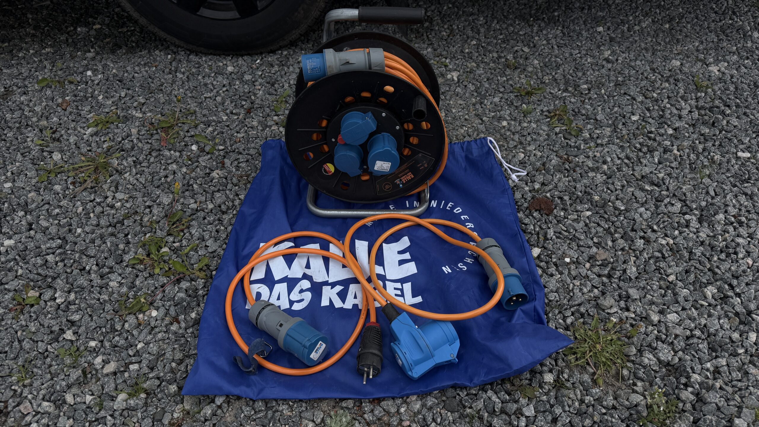 KALLE DAS KABEL CEE-Campingkabeltrommel EXTREME SIGNAL mit Adapterleitungen auf Stoffbeutel vor Wohnmobil im Praxistest